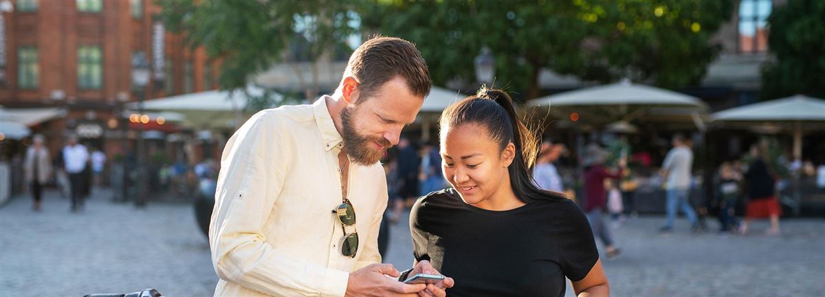 Par som ser på en mobiltelefon