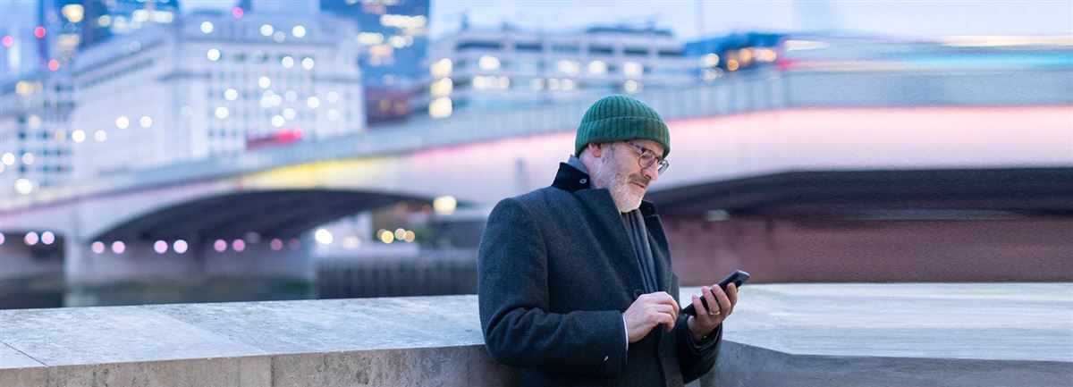 Mann på reise ser på mobilen sin