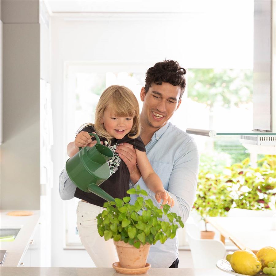 Far og datter vanner planter