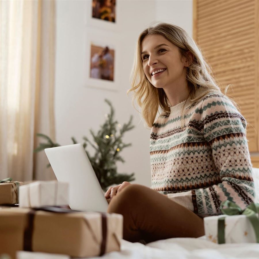 Kvinne med pc og julegaver