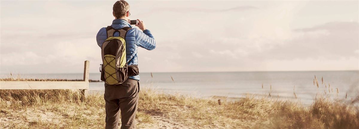 Mann tar bilder på stranden