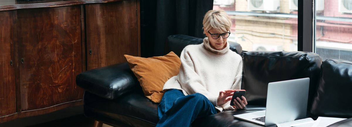 Kvinne sitter i sofaen