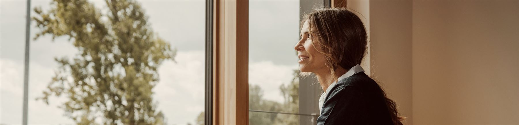 kvinne ser ut av vinduet