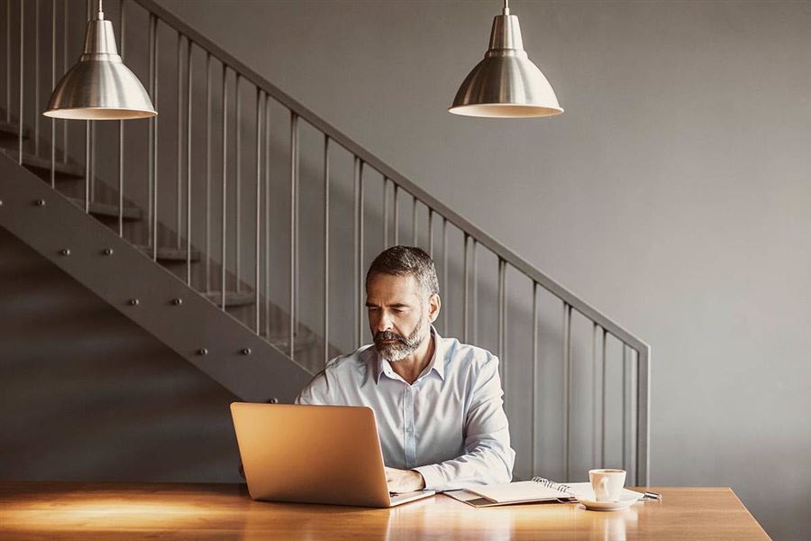 Mann som ser på sine fond i Handelsbanken på en laptop