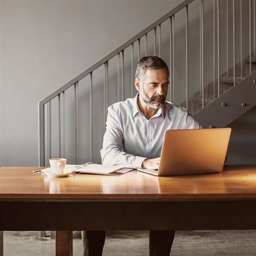 Mann bruker en laptop