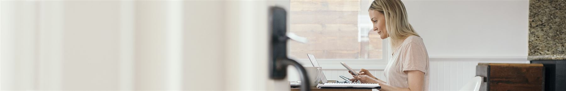 a woman sitting by a desk typing on her cellphone 