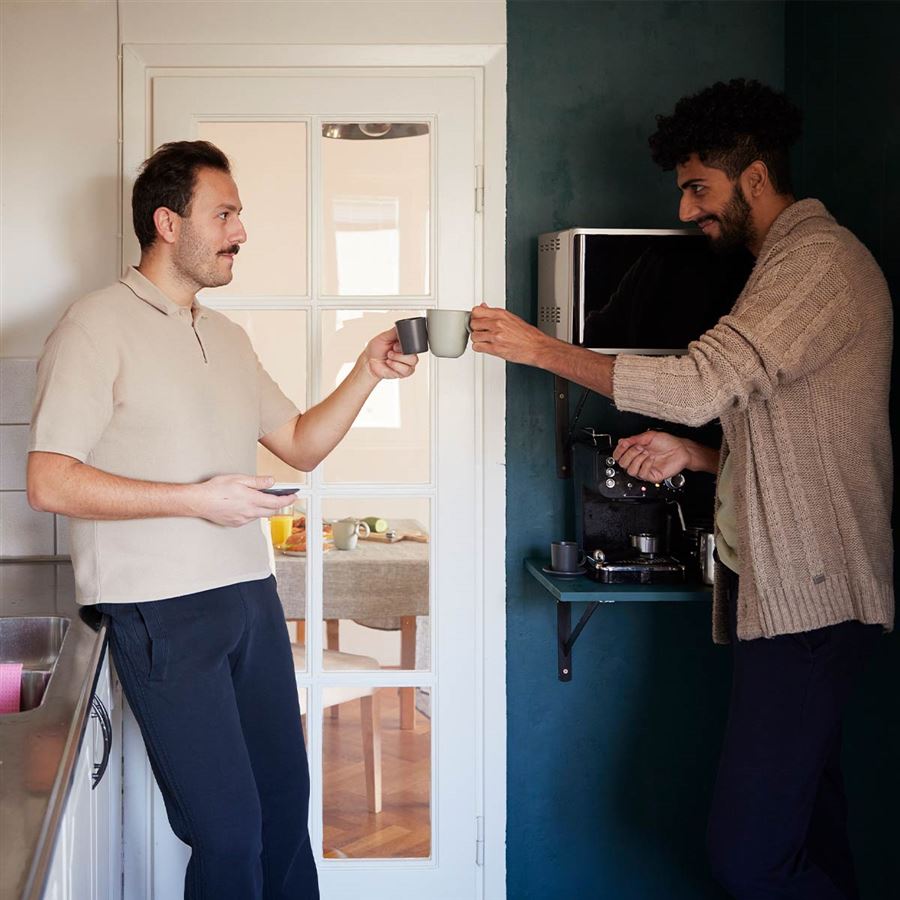 Two men cheering over a cup of coffee
