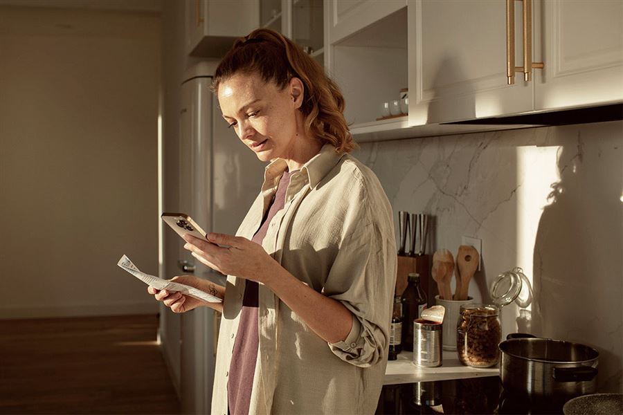 Woman with her phone in the kitchen