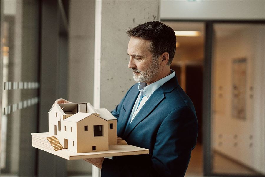 Man holding a model of a house