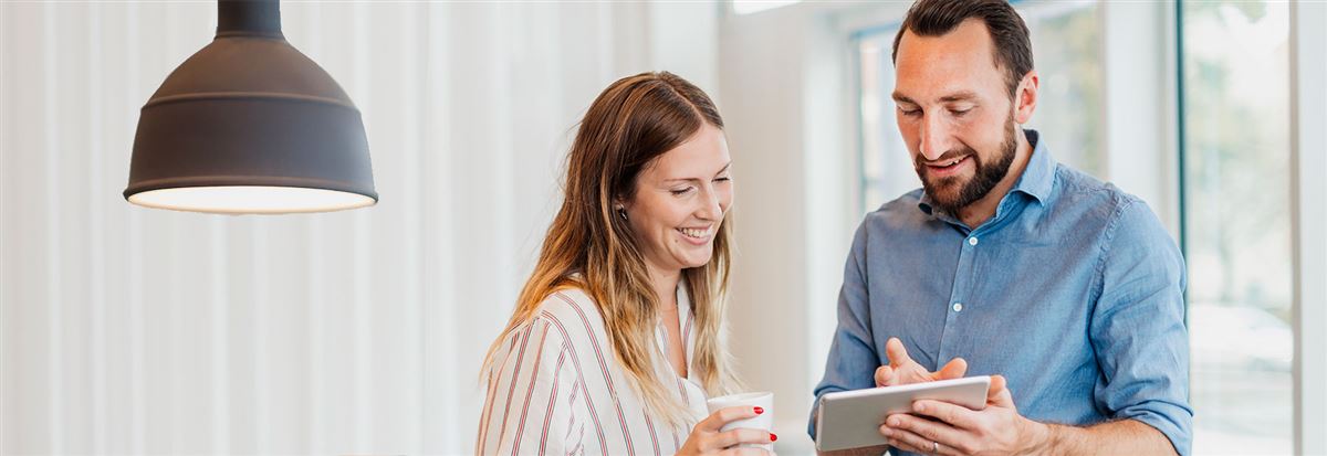 man and woman looking at an iPad